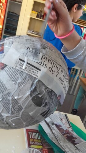 AS tiras de papel de jornal foram coladas com cola branca num balão de borracha