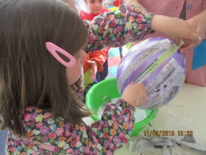 Envolver o balão com as tiras de papel molhadas em cola