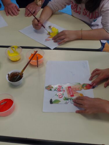 Crianças a pintar os frutos com tintas acrílicas sobre as embalagens de sumo da marca Compal.